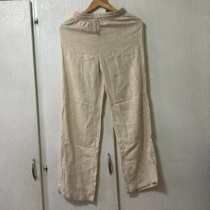 Beige linnebyxor från Shein - Snygga beige linnebyxor från Shein med elastisk midja för extra komfort. Perfekta för en avslappnad stil med en luftig känsla. Byxorna har en rak passform och är tillverkade i ett lätt och andningsbart material.