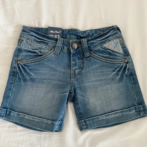 Jeansshorts - Snygga lågmidjade jeansshorts från Miss Vivi med coola detaljer på bakfickorna. Ny med prislapp