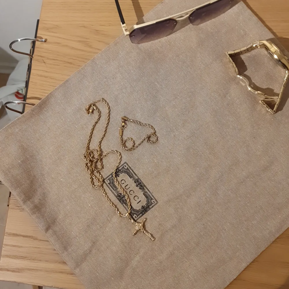 Elegant guldhalsband och matchande armband. Halsbandet har ett korshänge med detaljerad design. Båda smyckena har en vriden kedja som ger en lyxig känsla. Perfekt för att lyfta vilken outfit som helst. Du kan få välja antingen korset med en cordell kedja eller vetekedja💪märket heter CeletKedjorna är 55cm långa, Cordell armbandet är 5mm vetekedjan är 3mm och tillverkad av Kirurgiskt stål (316L). Vattentåligt, rostfritt och allergifri. Samt pläterad genom en PVD 18K guldplätering. Asusteet.