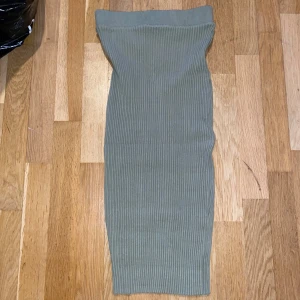 Grön ribbad kjol - Snygg grön ribbad kjol med en tight passform. Kjolen är knälång och har en elastisk midja för extra komfort. Perfekt för en stilren look.