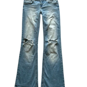 Blå bootcut jeans från Nelly - Snygga blå bootcut jeans från Nelly med slitna detaljer på knäna. Jag säljer de pga att jag inte använder dom 💞💞