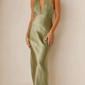 Super fin balklänning - Elegant grön långklänning i satin med djup v-ringning och öppen rygg. Perfekt för en glamorös kväll. Aldrig använd med prislapp kvar. Helt slutsåld 