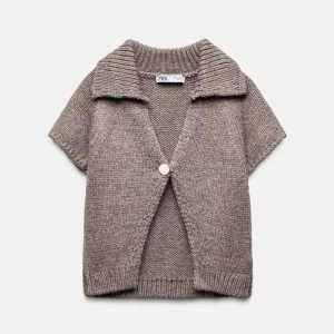 Beige brun stickad kofta från Zara - Säljer en mysig beige stickad kofta från Zara med korta ärmar och en stor knapp framtill. Perfekt för lager-på-lager-stil under svalare dagar. Den har en bred krage och ribbade kanter för extra stilpoäng. Som ny.