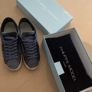 Blå sneakers från Philippe Model - Snygga blå sneakers från Philippe Model med en stilren design. Skorna har snörning och en rund tå, vilket ger en klassisk look. Perfekta för en avslappnad stil.