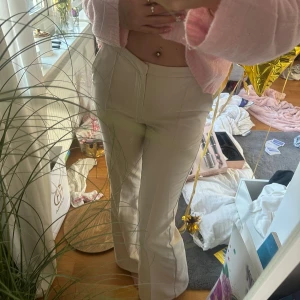 Beige kostymbyxor  - Snygga beige kostymbyxor  och bootcut-stil. Perfekta för en trendig look. De har en slät design utan synliga detaljer som knappar eller dragkedja framtill.