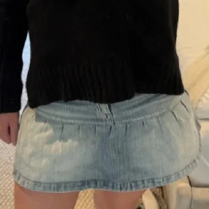 Ljusblå jeanskjol med veck - Säljer en ljusblå kort jeanskjol med snygga veck upptill och klassisk denimlook. Kjolen har en enkel design med knapp och dragkedja framtill. Perfekt för dig som gillar en chill och trendig stil.