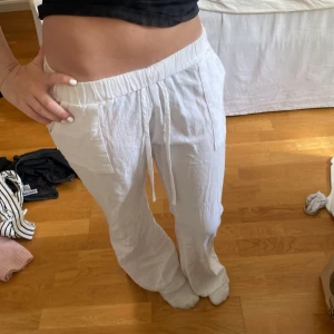 Vita linnebyxor med snörning - Säljer ett par vita linnebyxor med avslappnad passform och resår i midjan. På lappen står de att storleken är S men jag skullr säga att den passar mer som XS eller XXS
