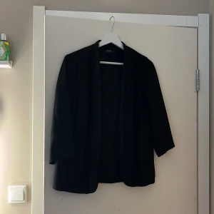 Tunn kavaj - Tunn kavaj i glansigt material med 3/4 ärmar. I storlek S!