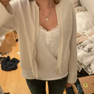 Vit kofta från Gina Tricot - Säljer en stilren vit kofta från Gina Tricot. Koftan har rund halsringning, ribbade muddar och är långärmad. Perfekt att slänga över en topp för en clean och enkel look.storlke S Materialet känns mjukt och lätt, passar till många outfits.är ganska nopprig men inget som syns på avstånd. Hör av dig om du har frågor eller funderingar 💕