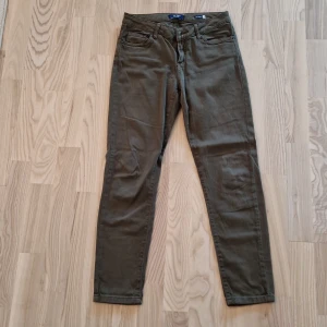 Olivgröna slim chinos från Koton - Snygga olivgröna chinos från Koton i slim fit-modell. Byxorna har klassisk femficksdesign, hällor för bälte och stängs med dragkedja och knapp. Perfekta för en clean och avslappnad look.