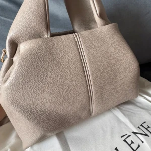 Beige axelremsväska från Polène i skinn neuf mini - Beige axelremsväska från Polène i skinn i modellen neuf mini. Dustbag finns