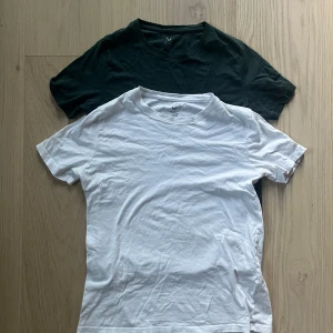 Grön och vit t-shirt från SOC - Två klassiska t-shirts från SOC, en i grön och en i vit. Båda har rund hals och korta ärmar, tillverkade i mjuk bomull.