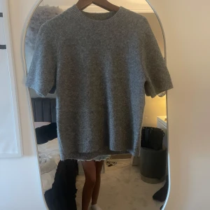 Grå stickad kortärmad tröja - Säljer en helt ny grå stickad kortärmad tröja materialet är helt underbart ny pris 499kr och jag säljer mer än halva priset, pris kan diskuteras💕💕💕.