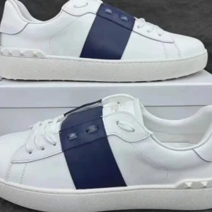 Valentino Open sneakers vit/blå skinn - Snygga Valentino Open sneakers i vitt skinn med bred marinblå rem över mitten. Klassisk rund tå, vita snören och ikoniska nitar på hälen. Perfekta för dig som gillar stilrena och exklusiva sneakers med en twist. Helt nya kommer i box. Finns i storlekar 40-45, priset kan diskuteras vid en flexibel och seriös köpare. Nypris runt 7000 kr
