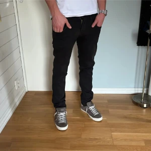 Svarta Replay jeans. I nytt skick , storlek 28/30 - Svarta jeans från Levis med slim passform och klassisk femficksdesign. Jeansen har en rak midja och är tillverkade i mjukt denimtyg som sitter snyggt längs benen. Perfekta för dig som gillar en stilren och enkel look.