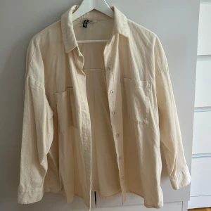 Beige overshirt i manchester  - Säljer en beige overshirt i mjuk manchester från H&M. Skjortan har två stora bröstfickor, knäppning framtill och avslappnad passform. Perfekt att slänga över en tröja.