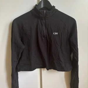 Svart croppad half zip tröja ICIW - Svart croppad tröja från ICIW med half zip framtill och den är helt ny med prislappen kvar 