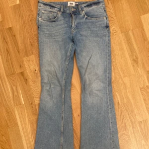 Blå bootcut jeans från 157 - Säljer ett par klassiska blå bootcut jeans från 157 med fem fickor och normal passform. Jeansen har normal midja och är tillverkade i denim med lätt tvättad look. Perfekta för dig som gillar retrostil och vill ha ett par snygga utsvängda jeans.