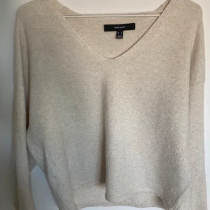 Beige stickad v-ringad tröja från Vero Moda - Mysig beige stickad tröja från Vero Moda med v-ringning och långa ärmar. Perfekt för lager-på-lager och enkel att matcha med olika outfits. Tröjan är lite nopprig men går att ta bort💗