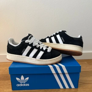 Adidas campus 00 - Adidas campus 00, använda 5-6 gånger kanske så i mycket bra skick! Små tecken på användning i form av smuts som man kan se på bilderna men inga hål eller slitage (lite nopprigt vid hälen som man kan se men så blev det efter 1 användning:/ ). Orginalkartongen och extra snören medföljer! Strl. 37 1/3