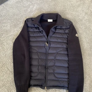 Mörkblå/svart Mocler cardigan  - Säljer nu min Mörk blå/svart cardigan från moncler. Tröjan är i storlek M men passar även för dig som har mellan storlekarna S och M. Tröjan är i väldigt bra skick och har inga tecken på användning. Säljer pga att jag växt ur den. Mitt pris är 3999kr men är inte ristat i sten vid snabb affär. Hör gärna av dig vid frågor och funderingar!