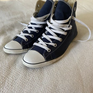 Mörkblå Converse sneakers - Säljer ett par klassiska mörkblå Converse sneakers med smal sula. Använda ytterst lite.
