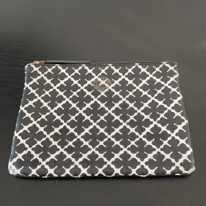 Svartvit kuvertväska från By Malene Birger - Snygg kuvertväska från By Malene Birger i svart och vitt med grafiskt mönster. Väskan har dragkedja upptill och är perfekt för att bära det. På sista bilden la ni se att det har fått lite missfärgning i men det är inget som syns på utsidan. 