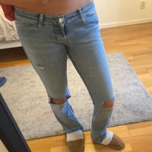 Lågmidjade jeans med hål  - Säljer dessa jättefina lågmidjade jeansen med hål på knäna. De är storlek 38 men skulle säga att de passar mer som 36/34. Perfekta för en stilren look! 💞💞