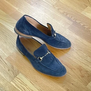 Mörkblå mocka loafers Storlek 41 - Snygga mörkblå loafers i mocka Storlek 41. Skorna har rund tå och platt sula, Skriv för mer bilder. 