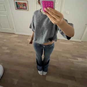 Grå stickad tröja - Säljer en stilren grå stickad tröja med trekvartsärm. Tröjan har en lös passform och är perfekt för en avslappnad look. Den är mjuk och bekväm, vilket gör den idealisk för kyligare dagar. Aldrig använd, bara testad