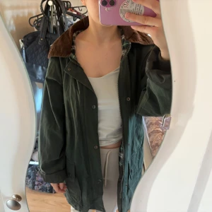 Grön regnjacka från Countrywear - Världens sötaste regnjacka från Countrywear. Jackan är vaxad vilket gör den väldigt vattentät och slittålig. För att uppfylla sitt fulla motstånd skulle jag dock rekommendera att vaxa/olja den en gång. Utöver det är den i fint skick, med många stora fickor. Är storlek XS, men den är ganska stor i passformen och skulle säga att den sitter som en M-L på mig som vanligtvis har XS/S.