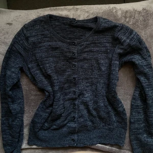Mörkgrå kofta med knappar - Köpt vintage. Skulle uppskatta den till storlek M fast den är inte så lång. 