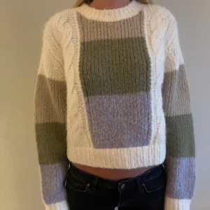 Stickad croppad tröja i blockfärger - Väldigt unik och supermysig stickad tröja med breda blockränder. Perfekt för dig som gillar en trendig och avslappnad stil.