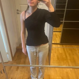 Zara oneshoulder topp - Säljer en svart oneshoulder topp med lång ärm på ena sidan från zara. Snygg och figurnära modell. Använd en kväll 🩵🩵