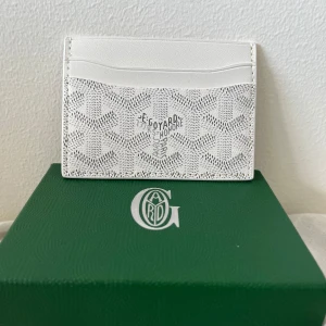 Vit korthållare från Gojard - Snygg korthållare från Gojard. Korthållaren har flera fack för massa kort och lite sedlar. Perfekt för dig som vill ha något snyggt i fickan och maxa ut din stil. Helt oanvänd och är helt ren. PRISET KAN DISKUTERAS