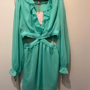 Cras klänning strl 40 - Beatracas dress från Cras i strl 40. Grön / mingrön färg. Material: polyester. Nypris: 2 030 kr  - V-ringning  - Volanger - Långa ärmar  - U-ringning midja  - Dragkedja överdel och underdel  - Lätt tyg med fint fall 