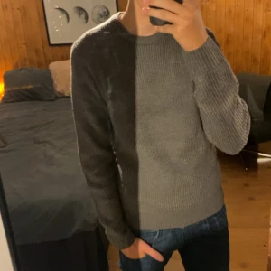 Stickad tröja - Säljer en stilren grå stickad tröja från Blend i storlek M. Tröjan har rund halsringning, ribbade muddar och är långärmad. Perfekt för lite kallare väder. 😀