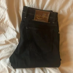 Svarta jeans från Jacob Cohen - Snygga svarta jeans från Jacob Cohen med kontrastsömmar och broderad J på myntfickan. Jeansen har klassisk femficksdesign och knäppning med flera knappar. Skicket är super!