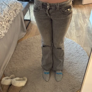 Grå bootcut jeans från Gina Tricot - Säljer grå bocut jeans ifrån gina (hållen har jag klippt) dom är 158 tall tror jag för jag är 167 och kan ha dom 
