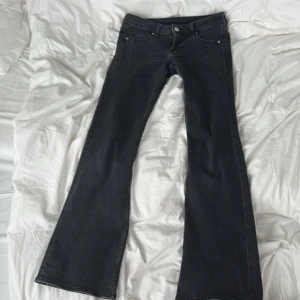 Svarta bootcut jeans - Snygga svarta jeans med bootcut passform och låg midja. Stretchiga material. Säljer för att de är för korta, jag är 174cm lång. Inga hål eller något sådant.