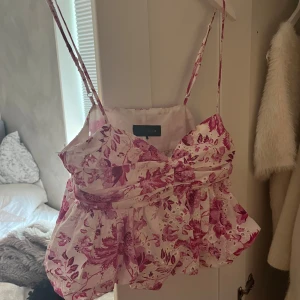Blommig volangtopp från Zara - Supersöt topp från Zara med rosa och lila blommigt mönster! Använt max 2 ggr så super bra skick!😇💕