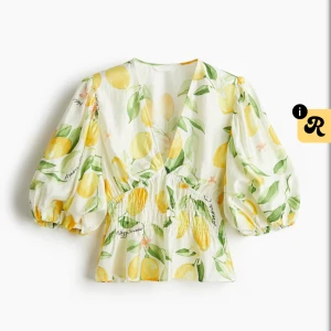 Citronmönstrad blus från H&M - Superfin blus från H&M med citronmönster i gult och grönt på vit botten. Modellen har puffiga korta ärmar, v-ringning och smockad midja som ger en snygg siluett. Perfekt för sommarens alla tillfällen!