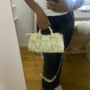 Beige handväska med kedjerem från Zara  - Säljer en beige handväska med coolt slitet utseende och silverfärgad kedjerem. 