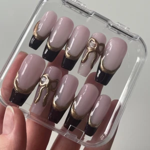 Lösnaglar med röd och guldig French tip och med rosett på en av naglarna  - Handgjorda lösnaglar som går att återvända flera gånger☺️ se storlek på sista bilden 