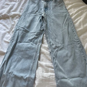 Ljusblå wide jeans från Lindex - Säljer ett par ljusblå jeans från Lindex i modell med breda ben. Klassisk femficksdesign och normalhög midja. Jeansen är i mjukt denimtyg och har en avslappnad, trendig passform som är perfekt till sneakers eller boots.