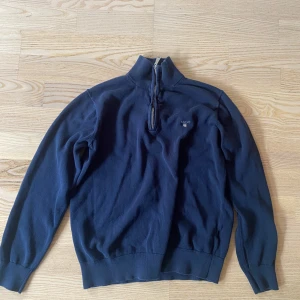Mörkblå half zip tröja från GANT - Mörkblå långärmad half zip från GANT, i storlek 158/164 13/14 år. Väldigt bra skick. Hör av dig vid frågor och funderingar! 