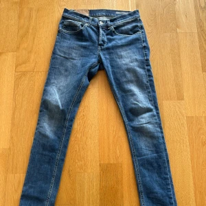 Blå skinny jeans från George - Snygga blå skinny jeans från George med klassisk femficksdesign och smal passform. Jeansen har en mellanblå tvätt med lätt slitning och kontrastsömmar. Perfekta för dig som gillar en tajt look och vill ha ett par stilrena jeans i garderoben.