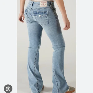 True Religion Joey Low Rise Flare jeans - Säljer ett par ljusblå True Religion Joey jeans med låg midja och utsvängda ben. Klassiska bakfickor med broderad logga och knappdetalj. Säljer dom för att dom alldrig kommer till användning💕