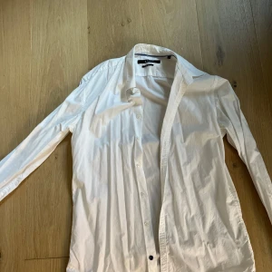 Vita skjortor slim fit från Tiger & Sir - Två klassiska vita kvalitetsskjortor i slim fit från Tiger of Sweden och Sir of Sweden. Båda har lång ärm, krage och knäppning framtill. Perfekta för dig som gillar stilrena och enkla plagg. Tillverkade i bomull för en skön känsla hela dagen. Hela och rena, finns på Södermalm. Slim fit stl 40. 100:-/st