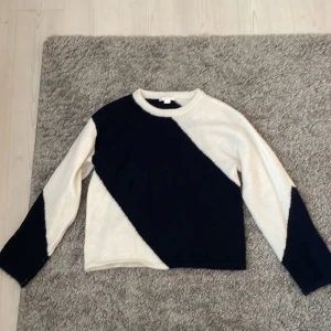 Randig stickad tröja från Gina Tricot - Snygg stickad tröja från Gina Tricot i storlek 170. Tröjan har ett coolt diagonalt randigt mönster i mörkblått och vitt, med långa ärmar och rund halsringning. Perfekt för dig som gillar en stilren men ändå unik look.